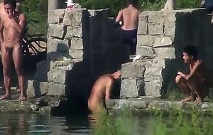 Chinese men swimming at lake -