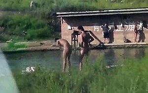 Chinese men swimming at lake -