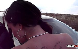 Brunette poses on the car before stripping